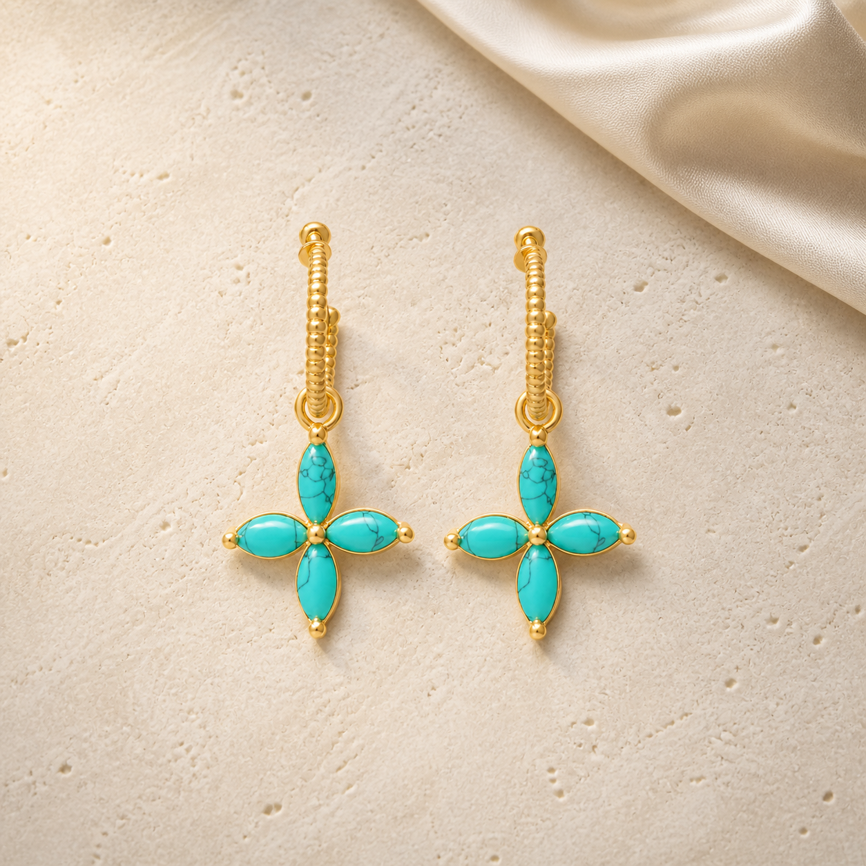 Aegean Cross Earrings on warm ivory travertine