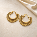 Sculpted Brass Statement Hoop Earrings on warm ivory travertine