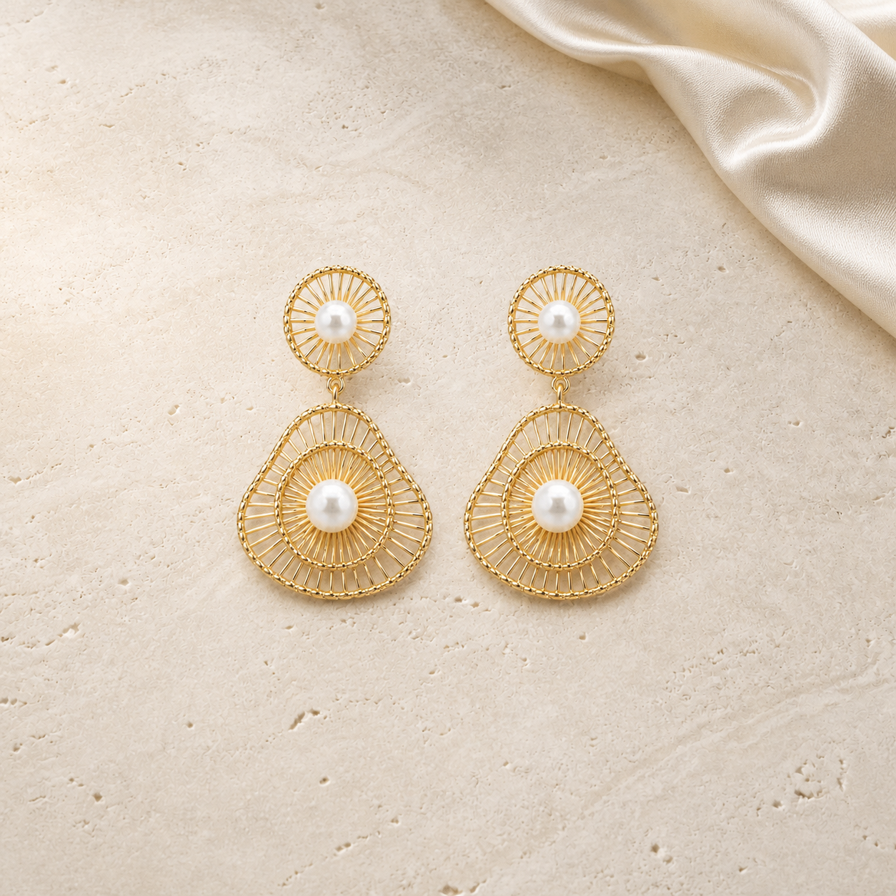French Retro Hollow Pearl Earrings on warm ivory travertine