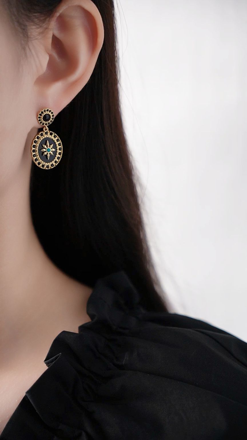 Gold medallion earrings with black stone