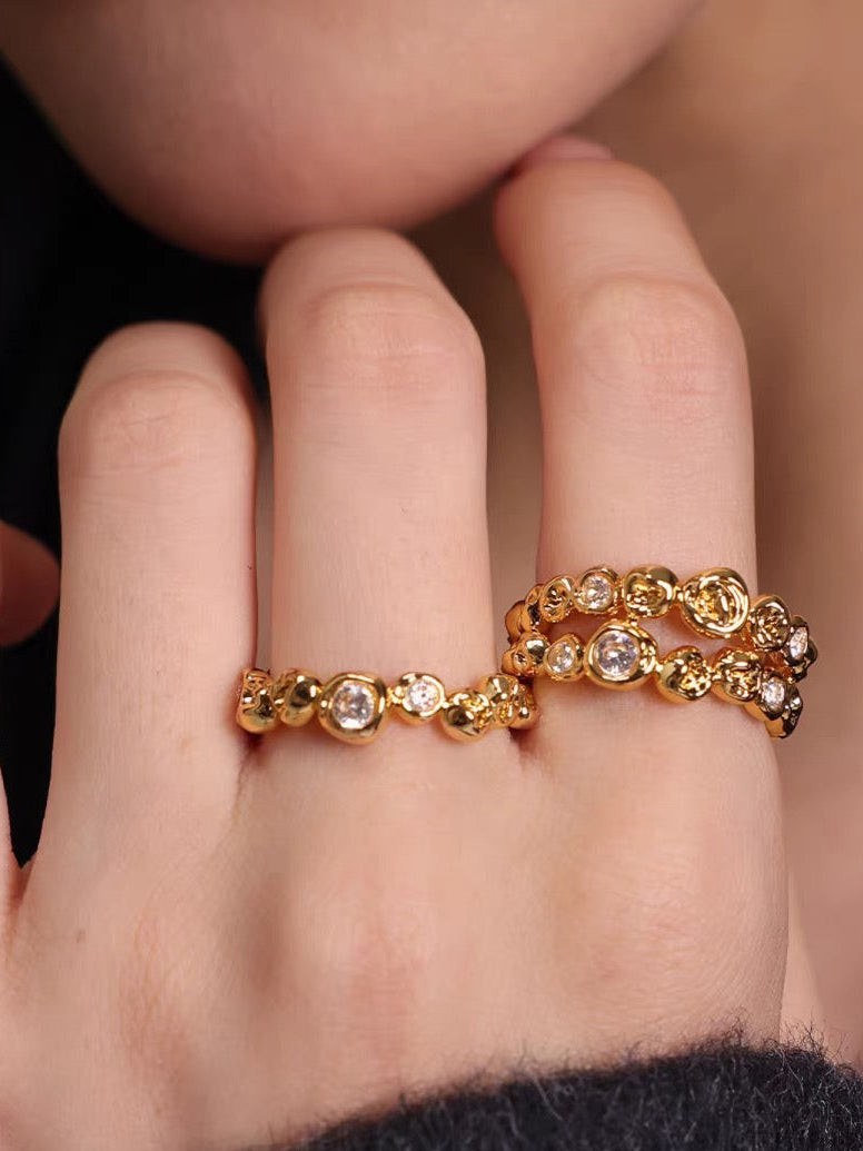 Gold ring with small diamonds on a person's finger