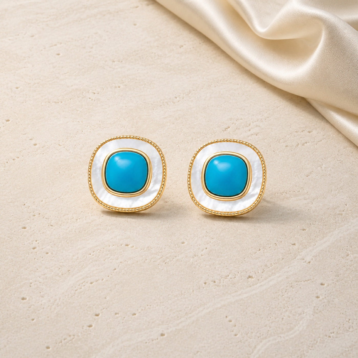 Artisanal Tiger Eye and Enamel Stud Earrings on warm ivory travertine