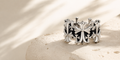 Lyastone Aster Cross Open Ring on warm travertine in natural light