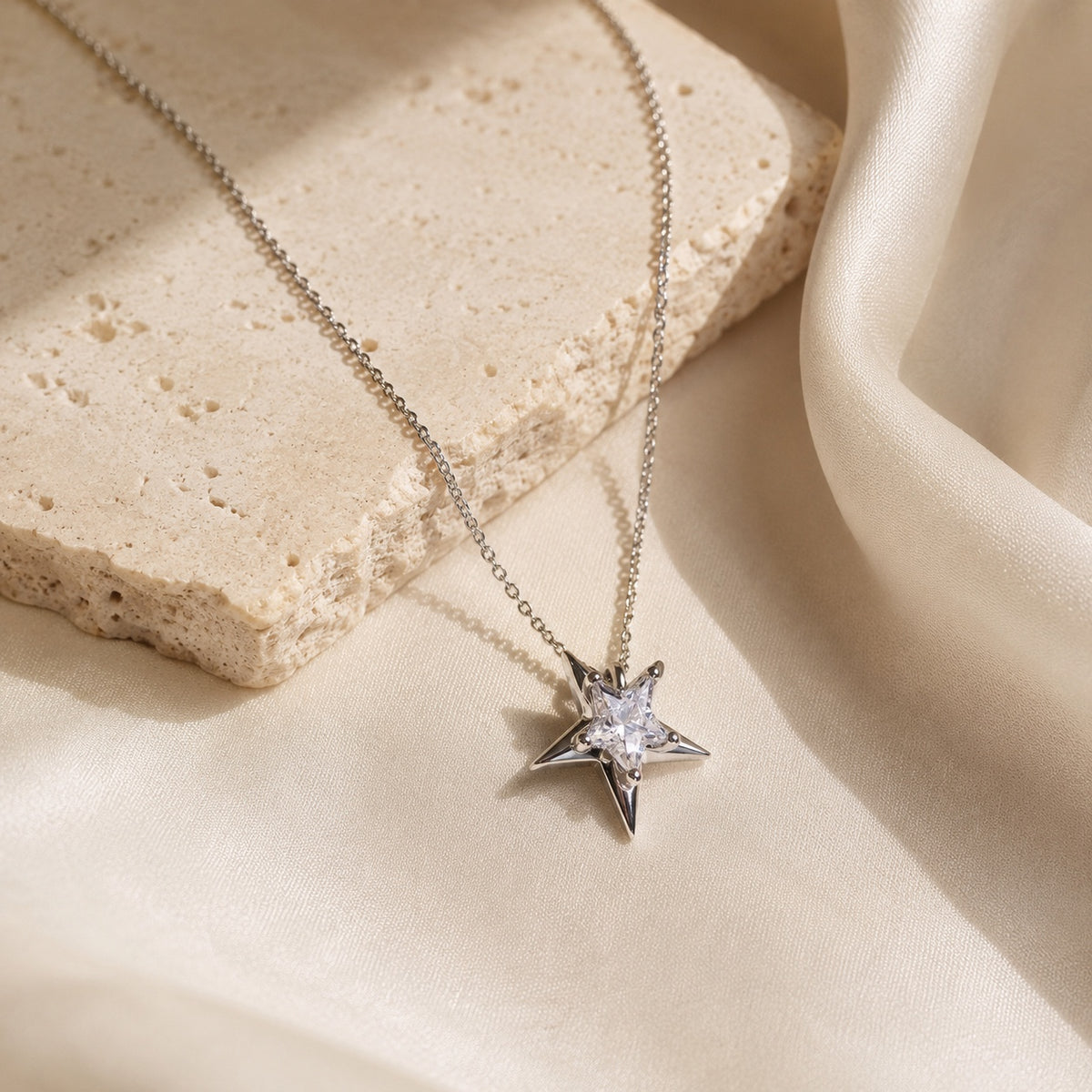 Astra Star Necklace styled on ivory satin and stone