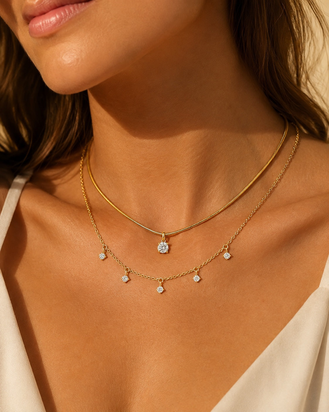 Aurelia Gold Solitaire and Five-Stone Necklace layered together on the neckline