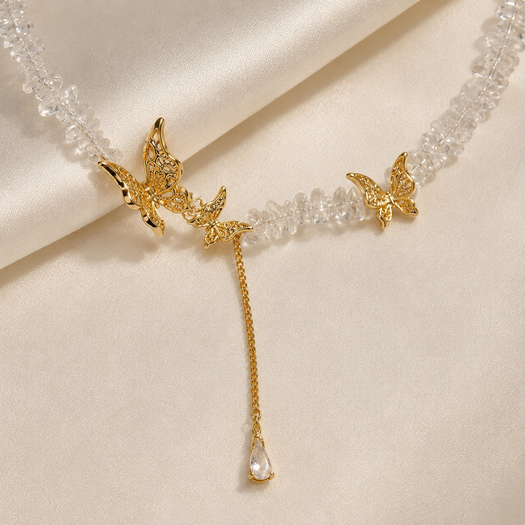 Close-up of gold tone butterfly details and clear crystal drop.