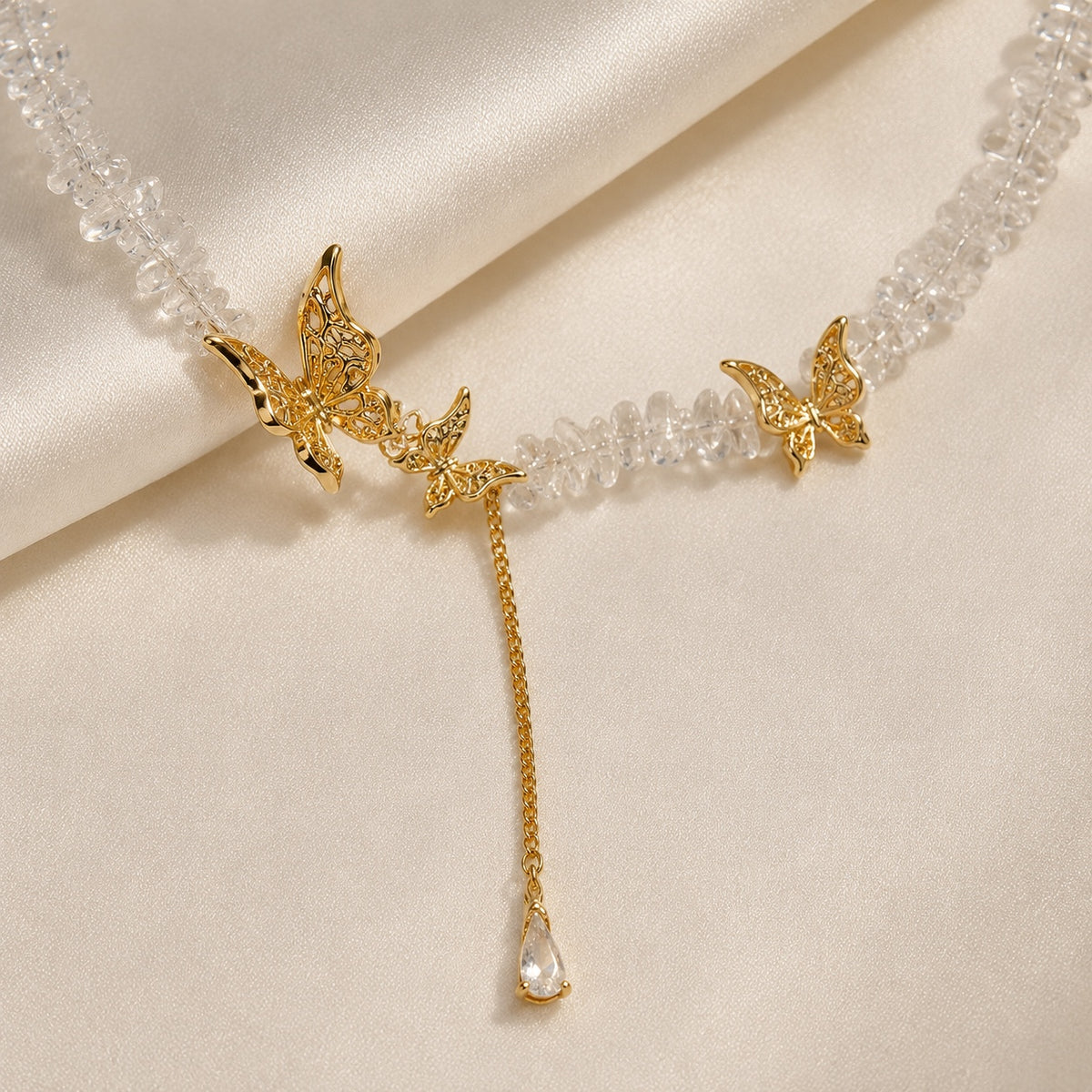 Close-up of gold tone butterfly details and clear crystal drop.