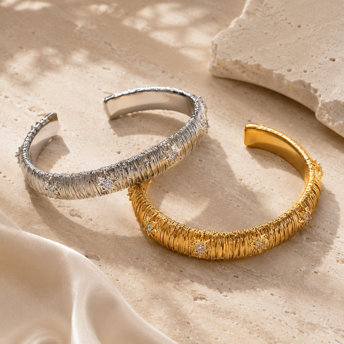 Dreamweave Star Open Cuff in gold and silver on warm travertine