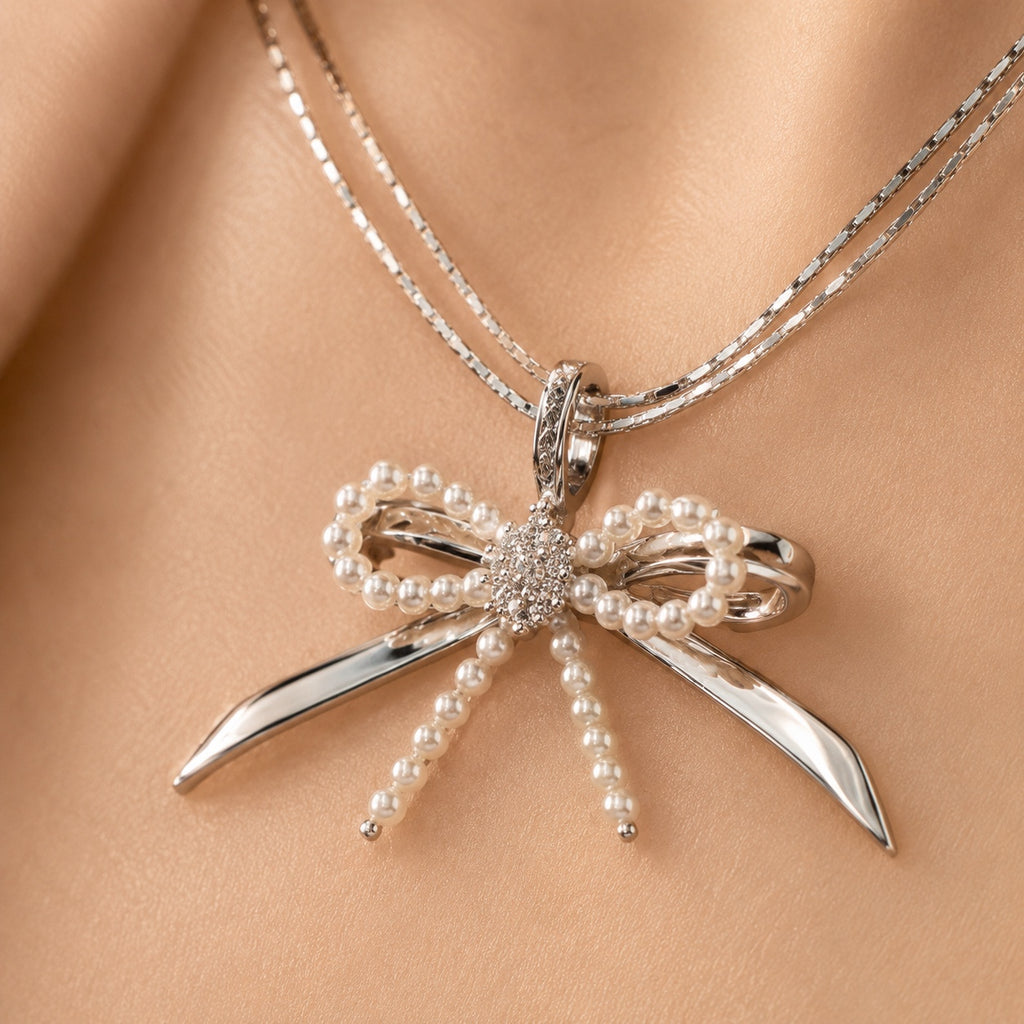Model wearing Élodie silver pearl bow necklace close-up