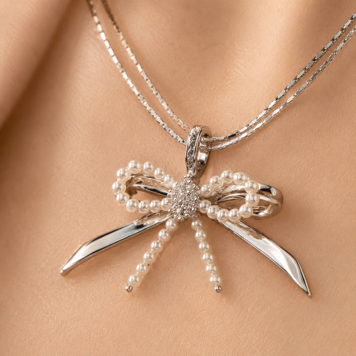 Model wearing Élodie silver pearl bow necklace close-up