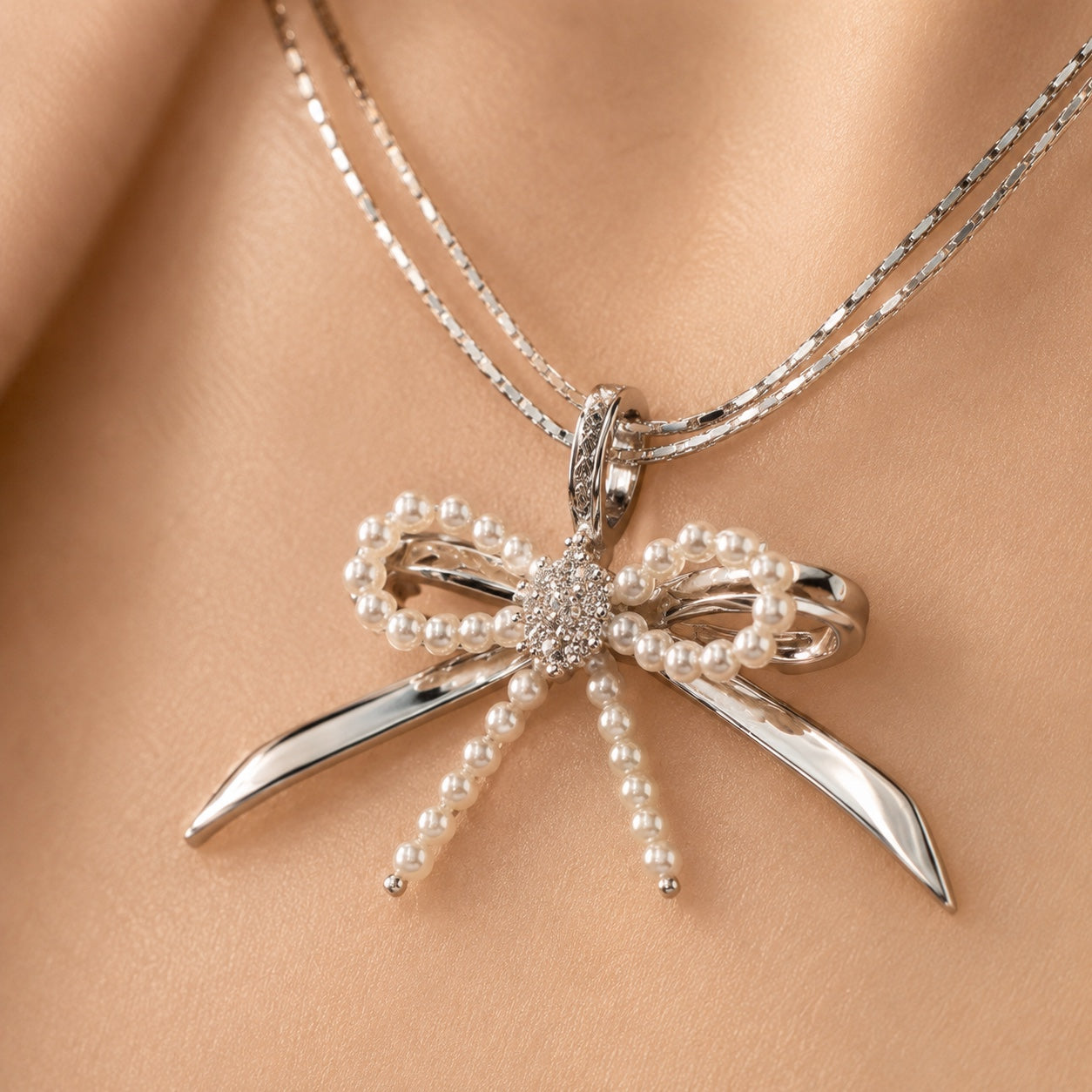 Model wearing Élodie silver pearl bow necklace close-up