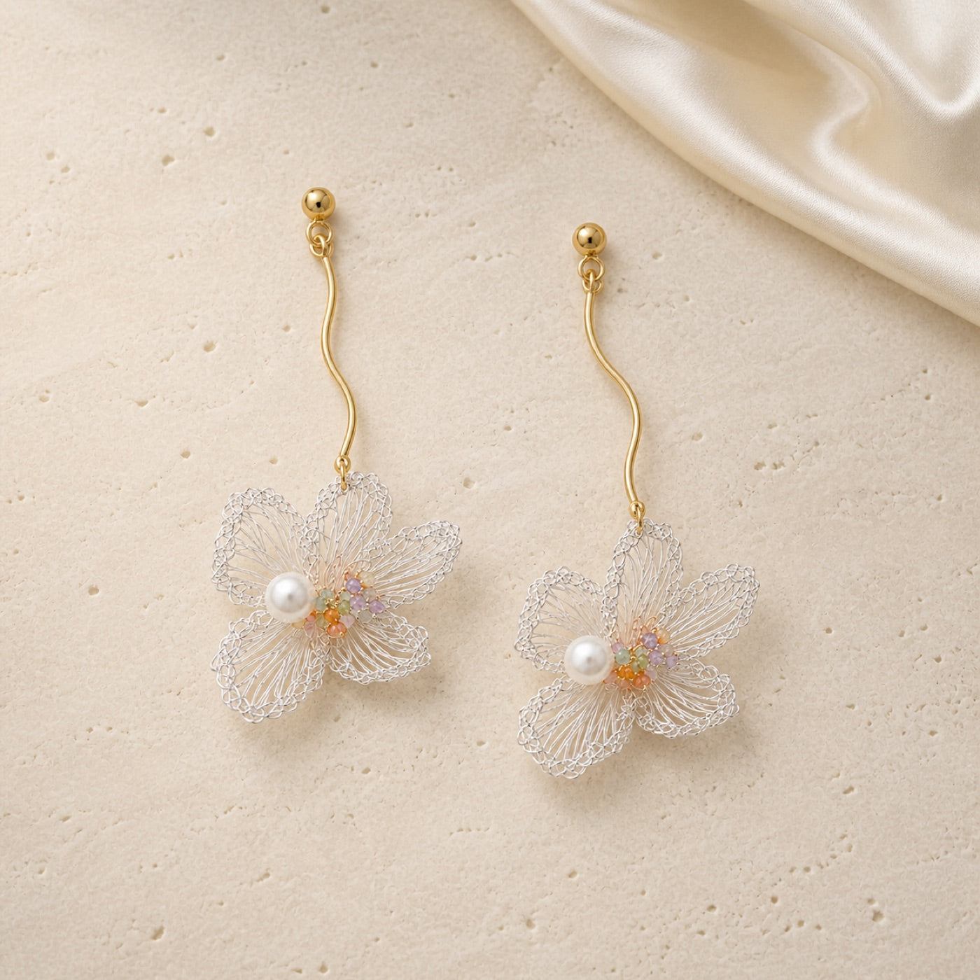 Ethereal Bloom Earrings on warm ivory travertine