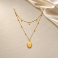 Golden Keepsake layered necklace in gold on ivory travertine