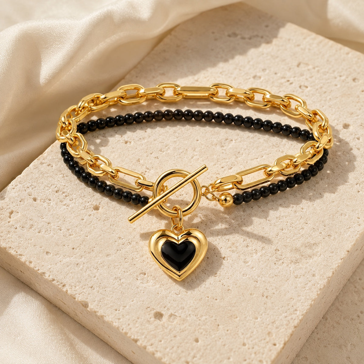Amoura Heart Toggle Bracelet in black agate styled on ivory stone and satin