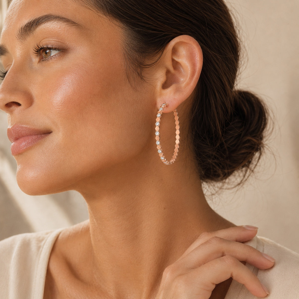 Rose gold honeycomb geometric hoop earrings on white background