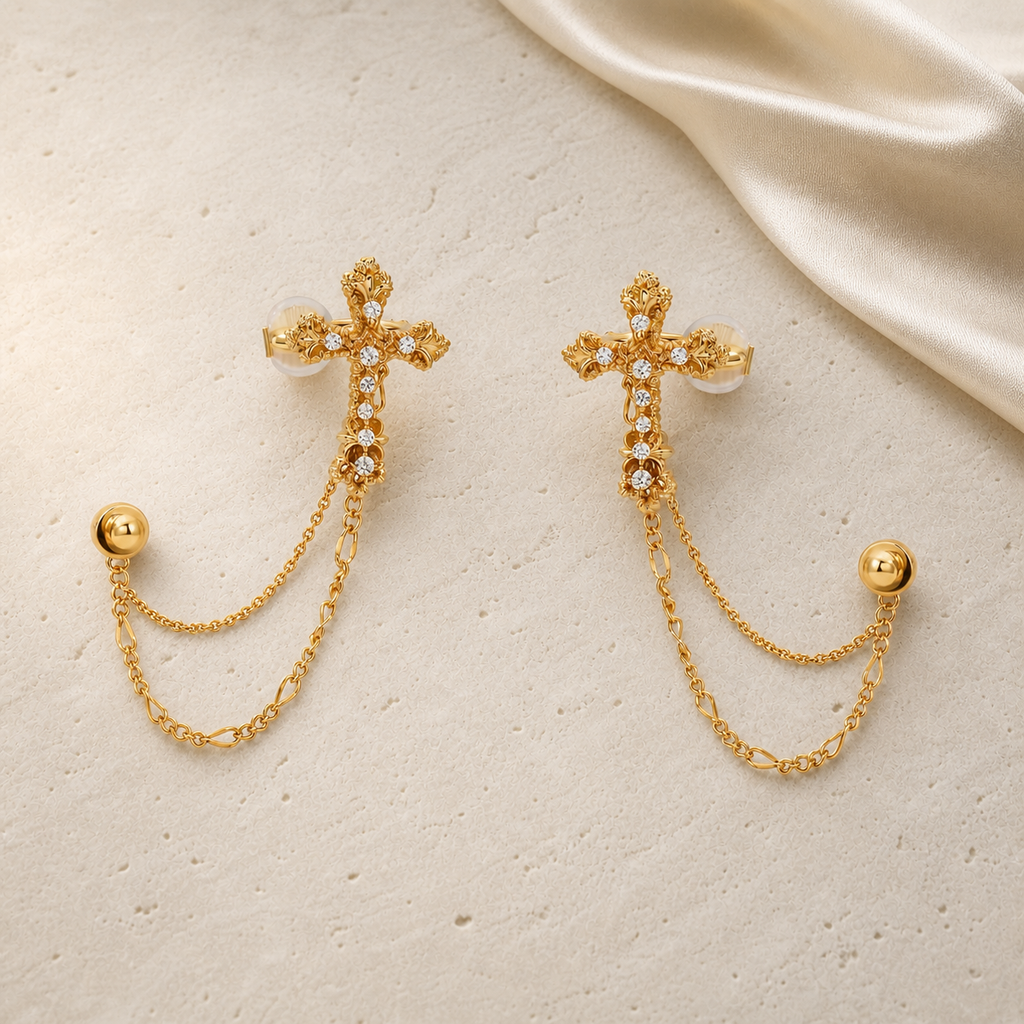 Imperial Cross Earrings in gold with clear stones on ivory travertine