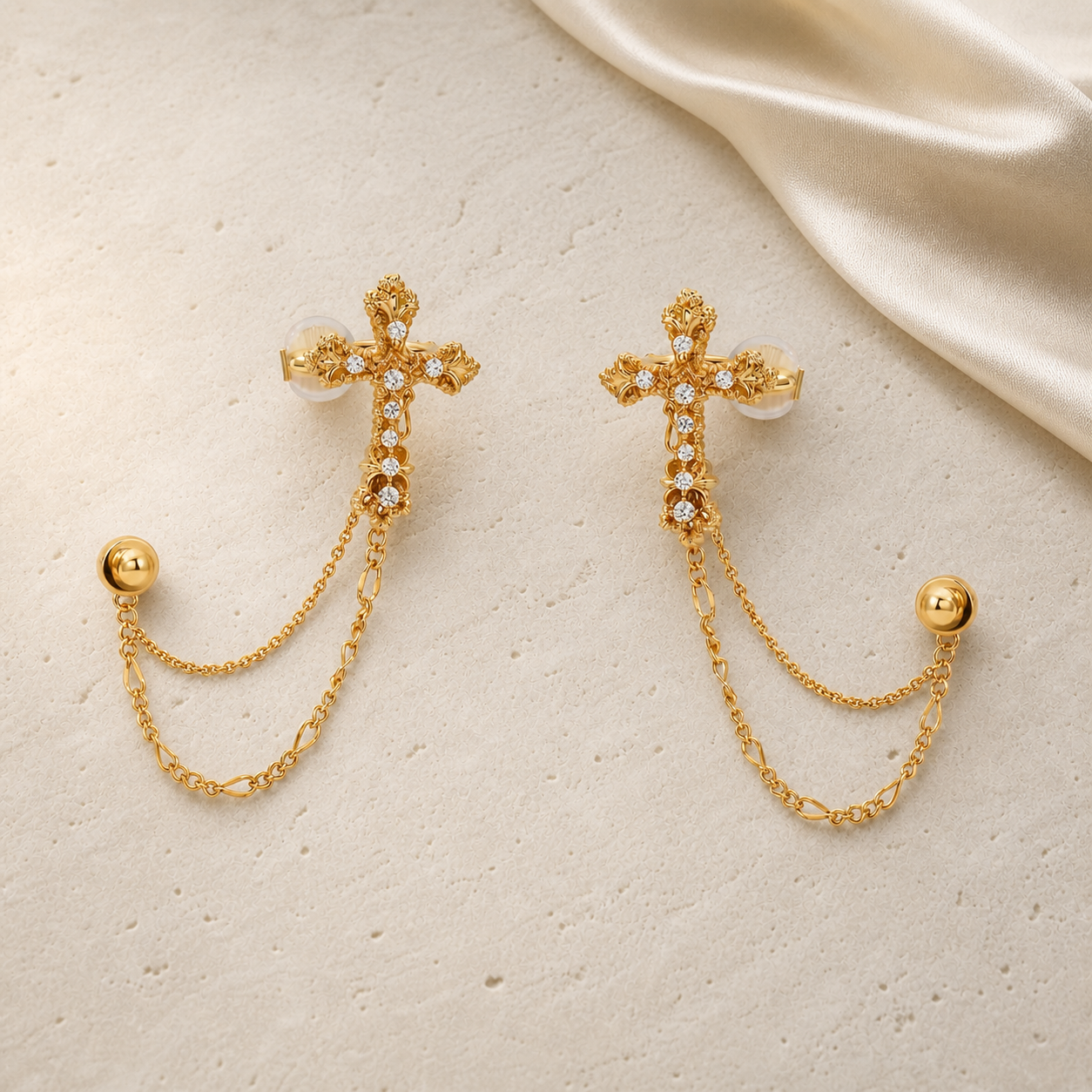 Imperial Cross Earrings in gold with clear stones on ivory travertine