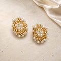Light Luxury Hollow Basket Pearl Earrings on warm ivory travertine