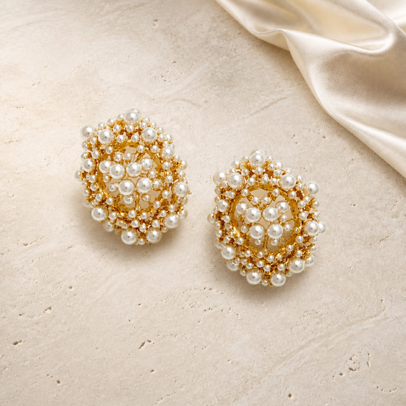 Light Luxury Hollow Basket Pearl Earrings on warm ivory travertine