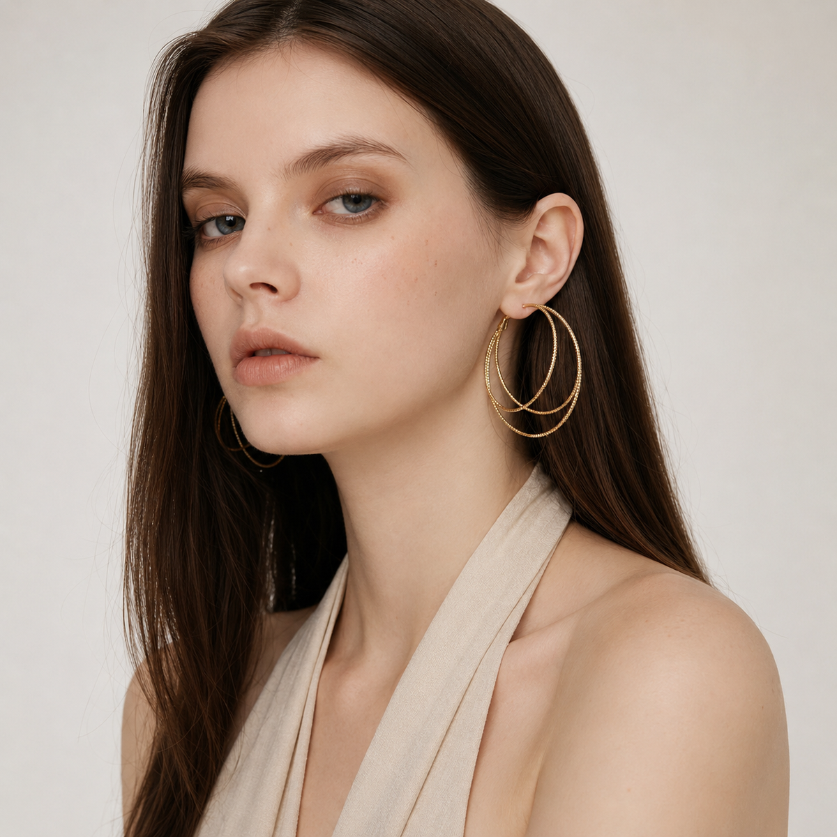 Model wearing Lyastone Aurelia triple hoop earrings in gold