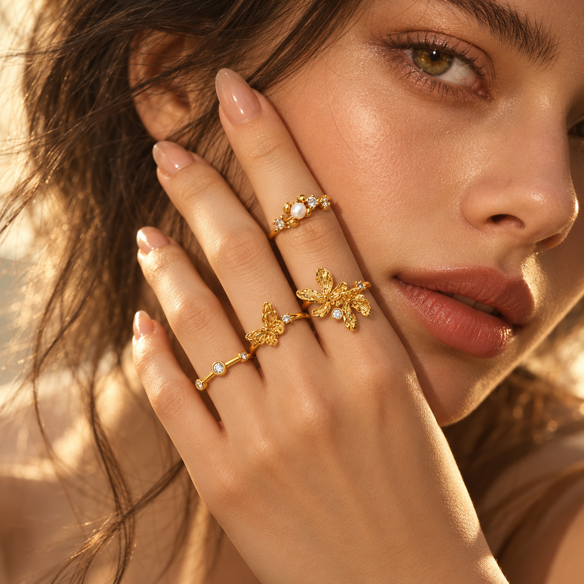 Butterfly Bloom Ring – model wearing gold butterfly and floral rings in natural warm light