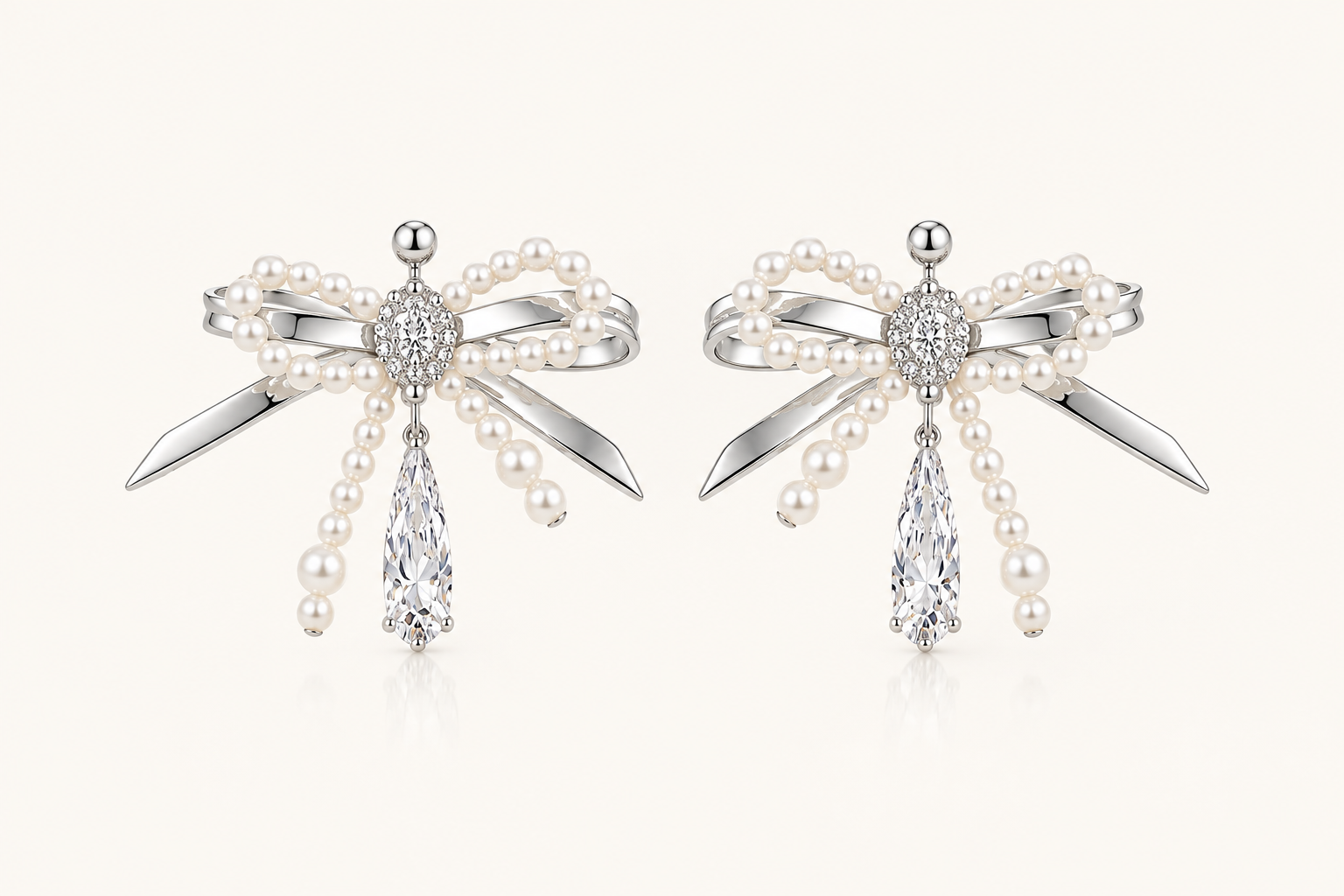 Silver pearl bow cubic zirconia drop earrings on warm ivory background