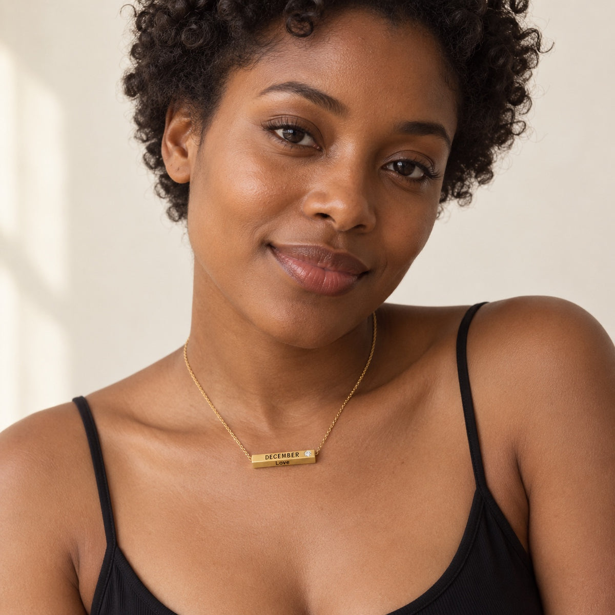 December Month of Love gold necklace worn on warm skin tone