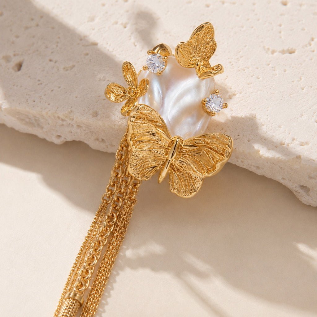 Close up of gold butterfly pearl chain earrings with cubic zirconia accents