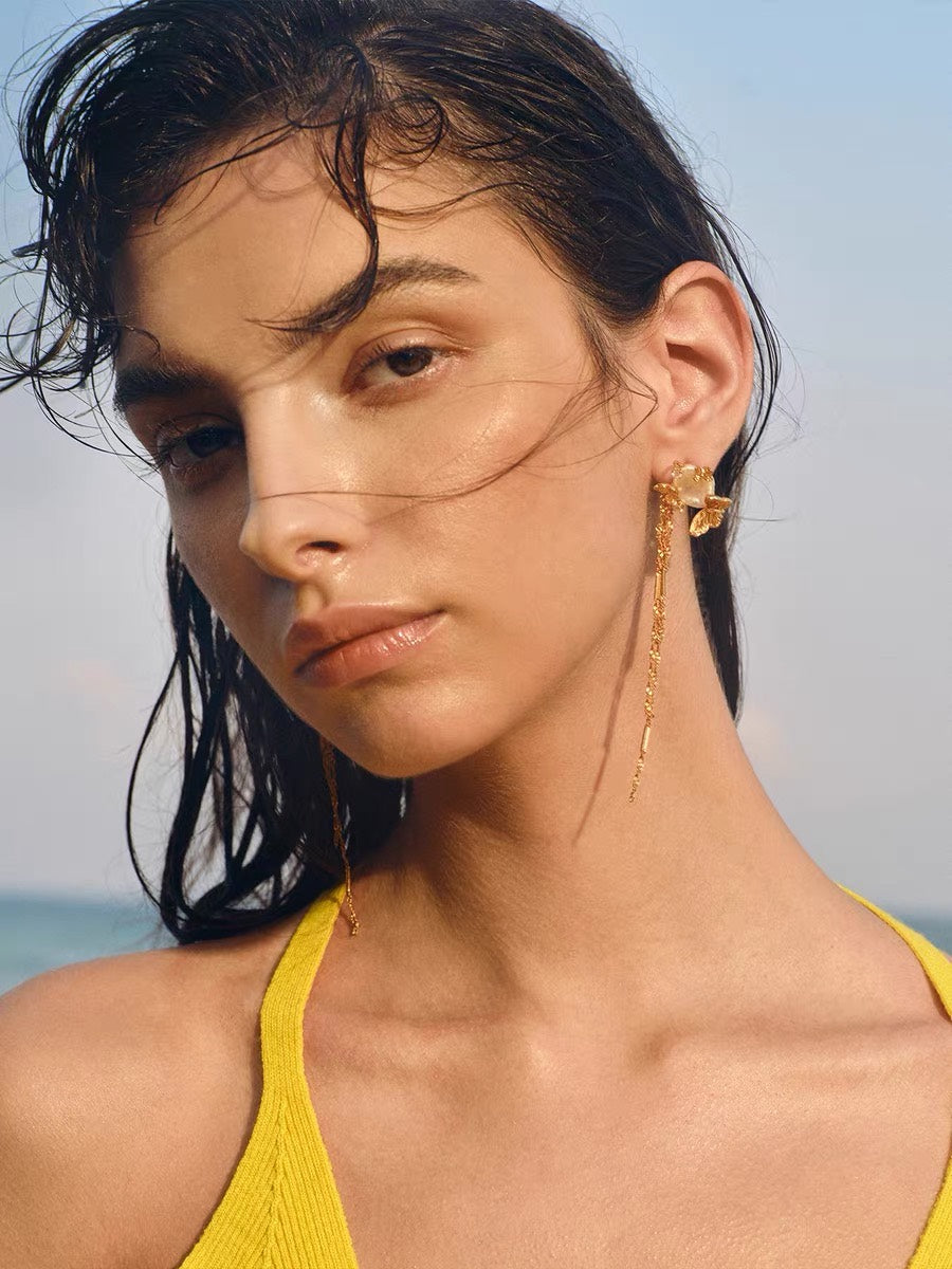 Sunlit Tide Butterfly Pearl Chain Earrings worn by the beach