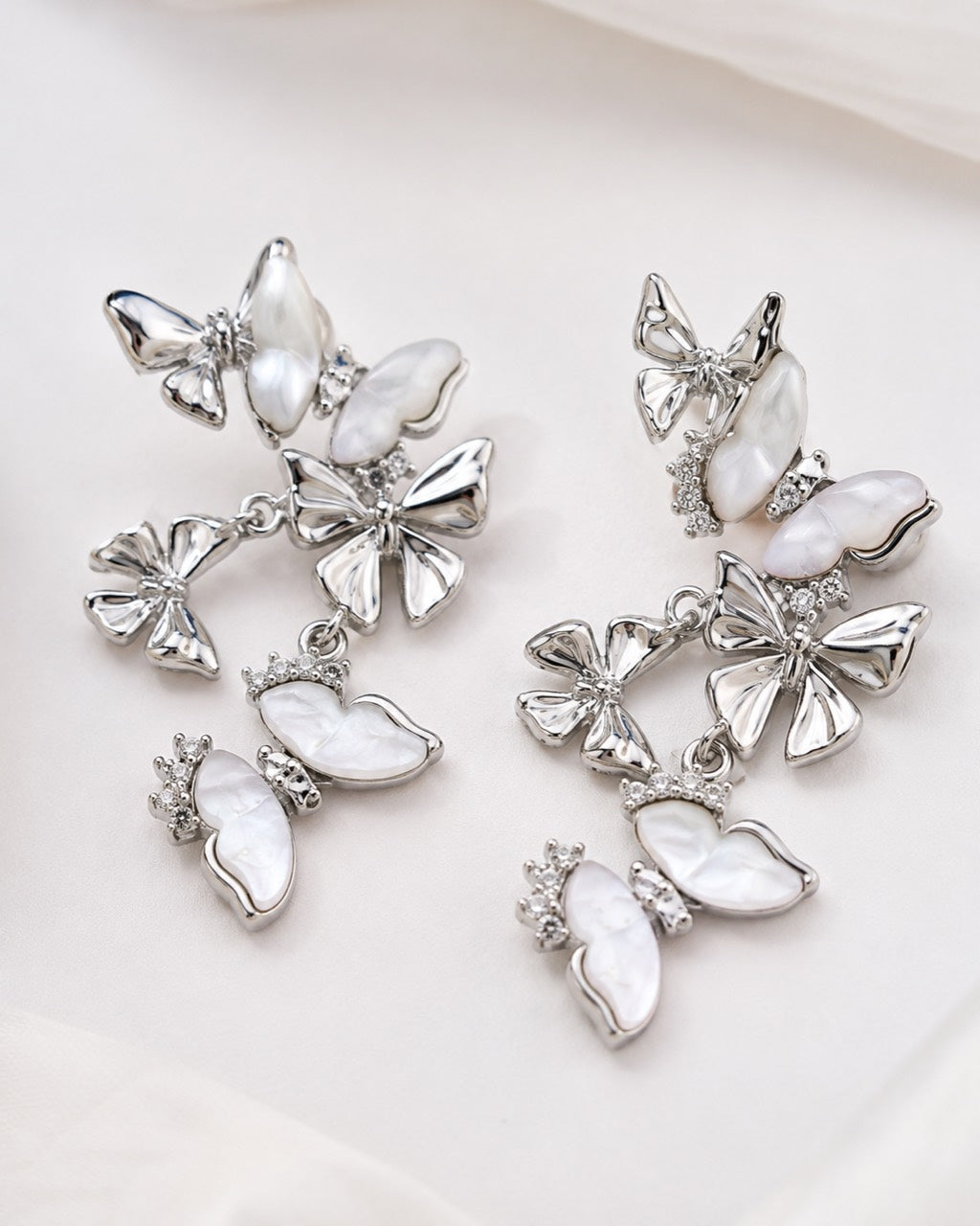 Close up of white mother of pearl butterfly drop earrings with cubic zirconia accents