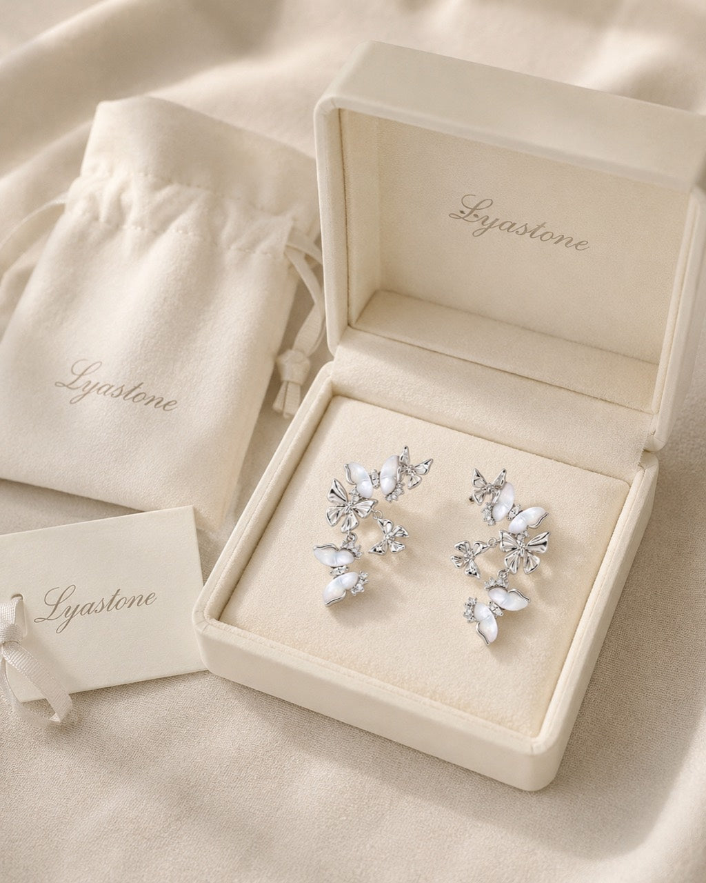 White mother of pearl butterfly drop earrings displayed in Lyastone gift packaging
