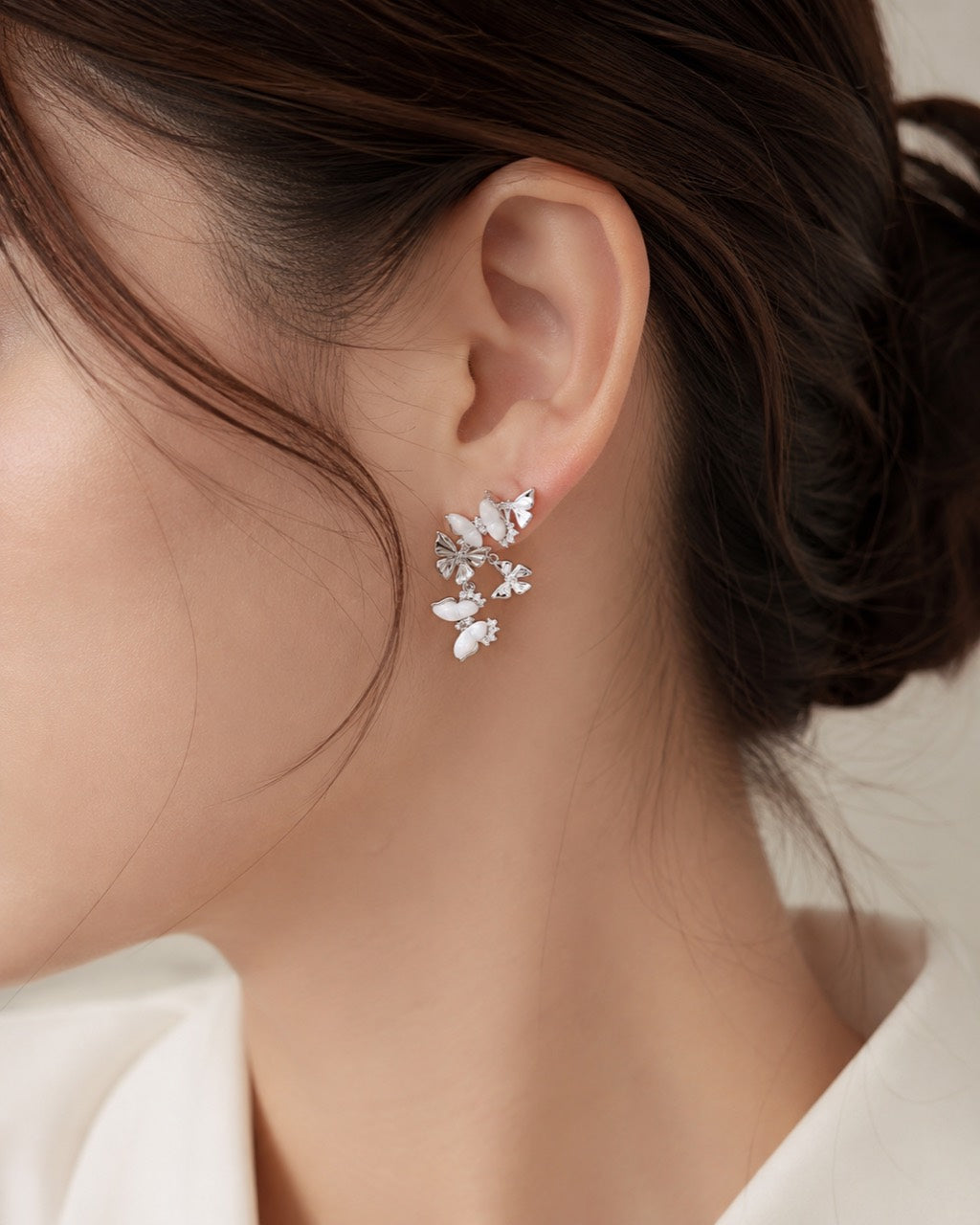 White mother of pearl butterfly drop earrings worn on ear by Lyastone