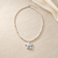 Ocean Star Silver Necklace on warm ivory travertine