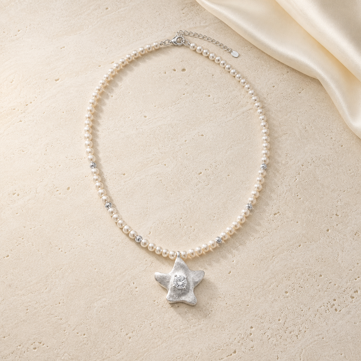 Ocean Star Silver Necklace on warm ivory travertine