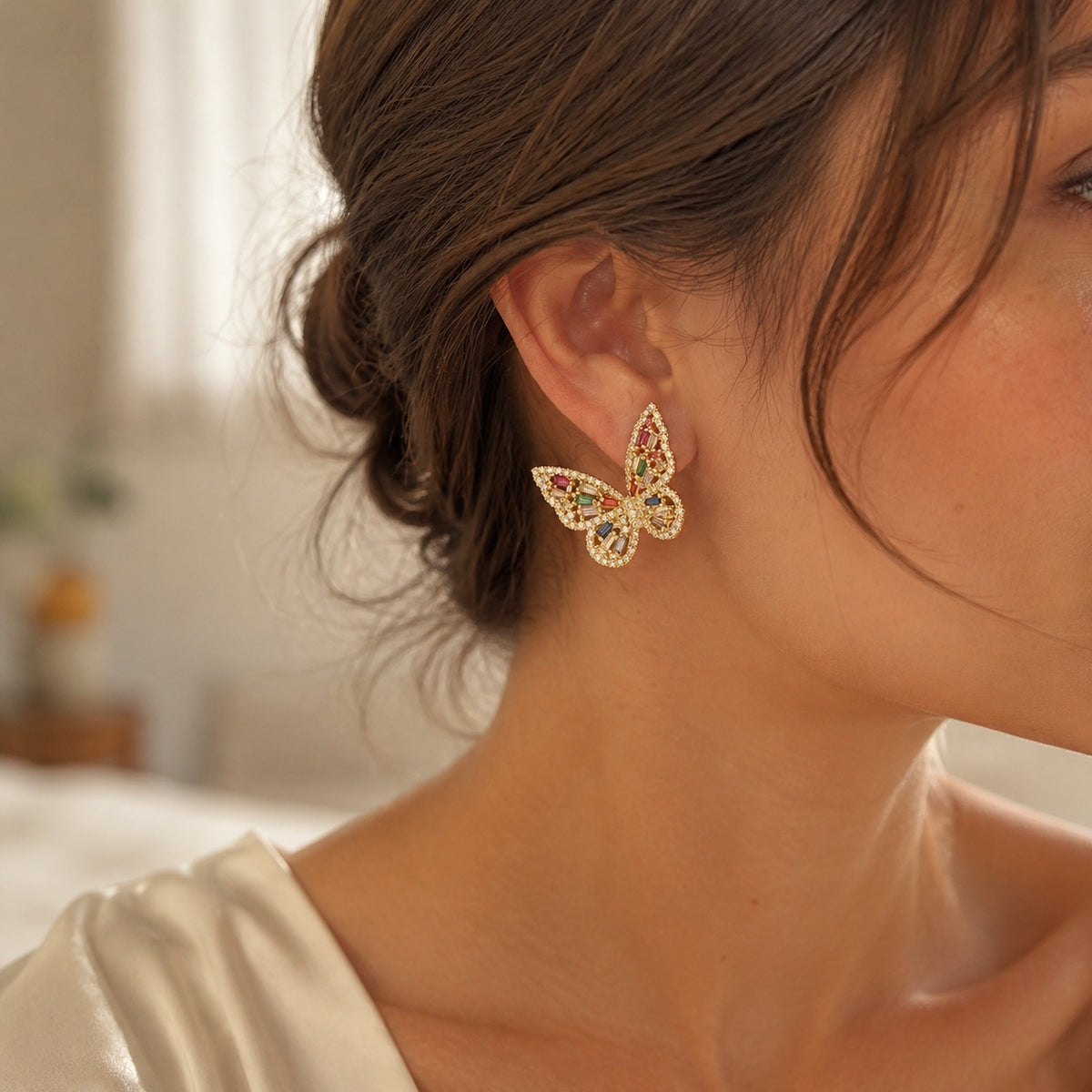 Model wearing Prism Flutter Butterfly Earrings in a warm indoor setting