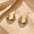 Solara Cascade gold and silver-tone chain hoop earrings on ivory travertine